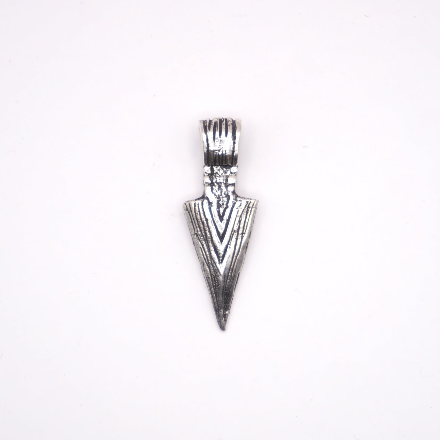 Pendentif en argent en forme de flèche, orné de gravures détaillées, issu de l'artisanat latino-américain. Produit de la boutique Altiplano.