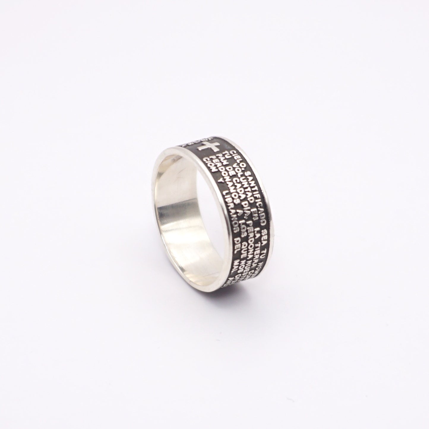 Une bague en argent avec une finition polie, ornée de gravures détaillées de textes et une petite croix en relief. Produit intitulé "PADRE", disponible chez Altiplano, une boutique en ligne spécialisée dans les bijoux latino-américains en argent.