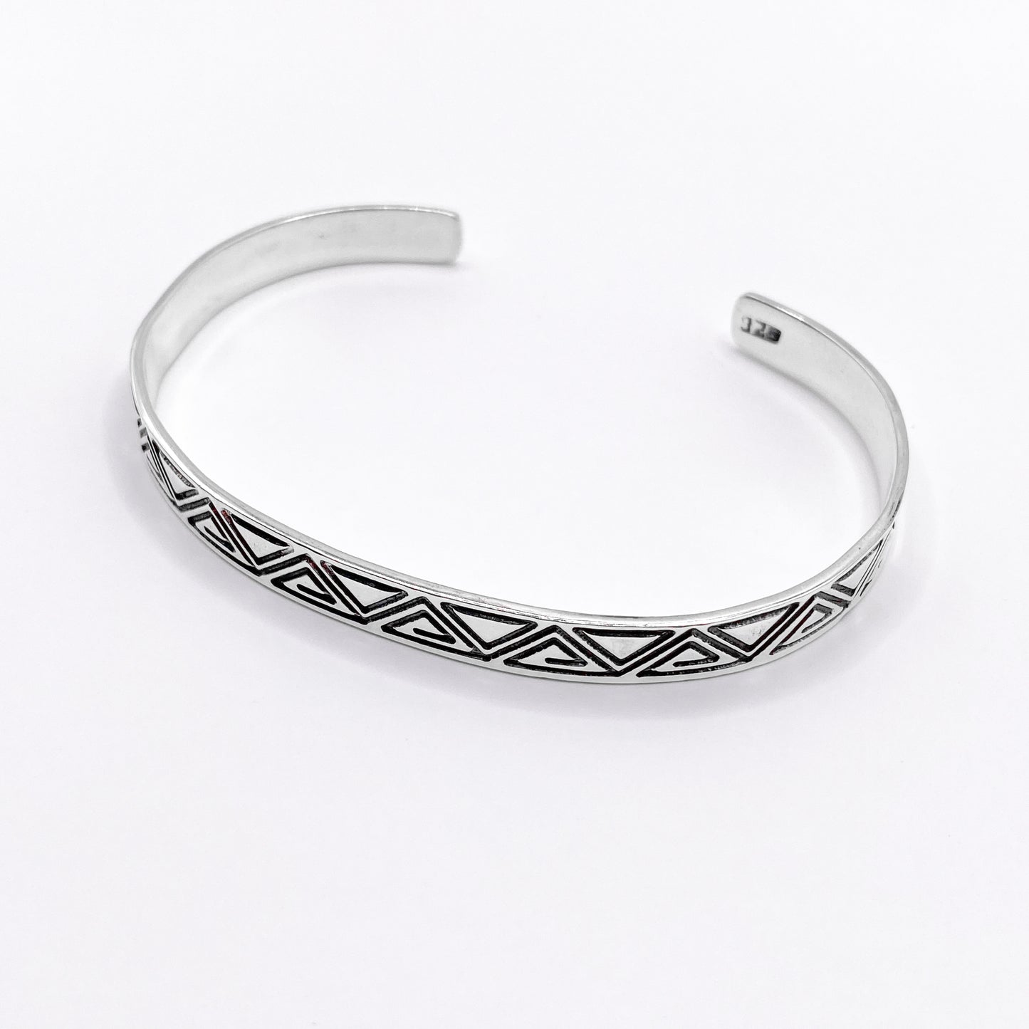 Bracelet en argent finement ciselé avec des motifs géométriques tribaux, produit artisanal de la boutique Altiplano. Le modèle "ZACUALLI" incarne le savoir-faire et l'élégance des bijoux latino-américains.
