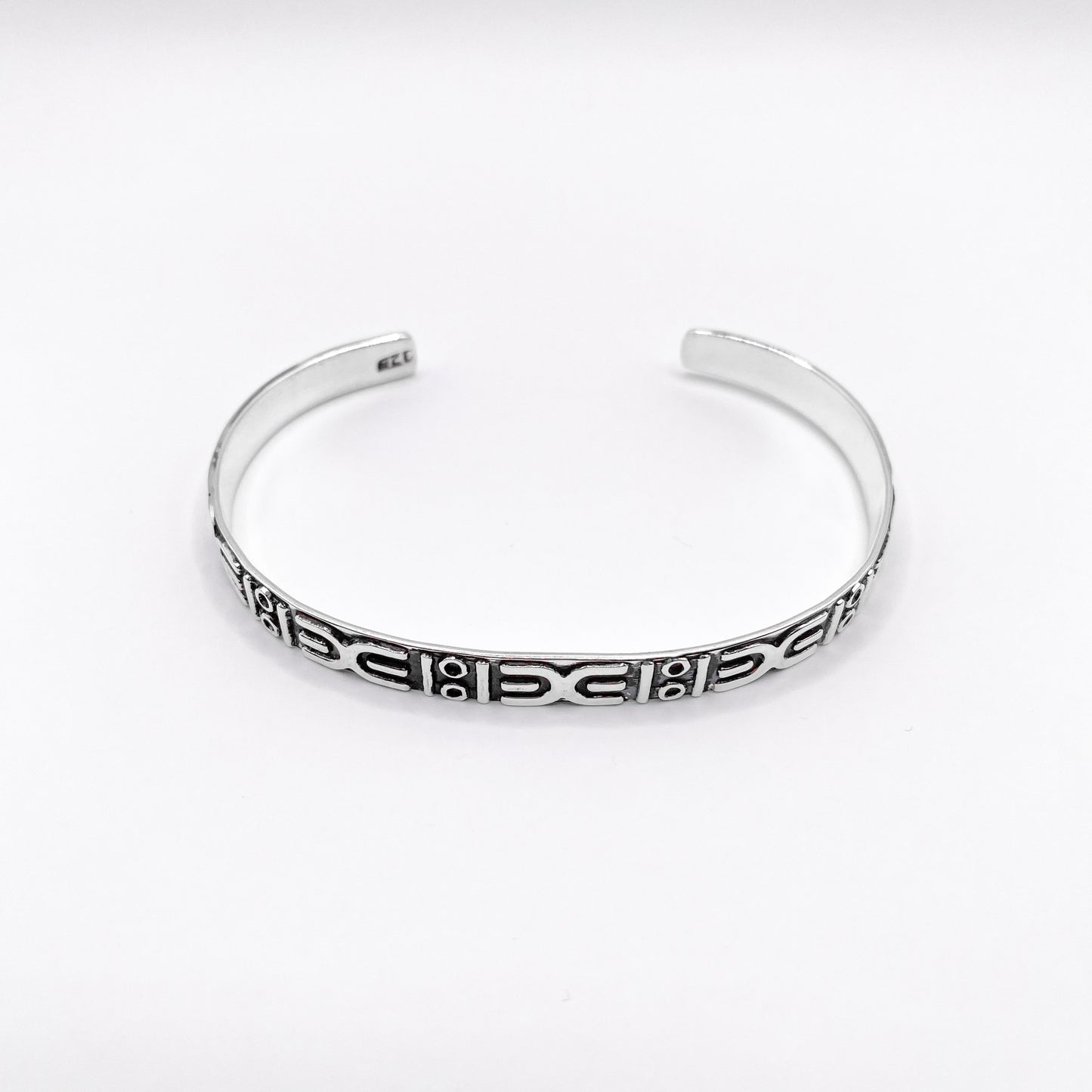 Bracelet ouvert en argent avec motifs ethniques gravés, issu de la boutique en ligne Altiplano. Modèle "APANSAKA" reflétant l’artisanat traditionnel latino-américain.