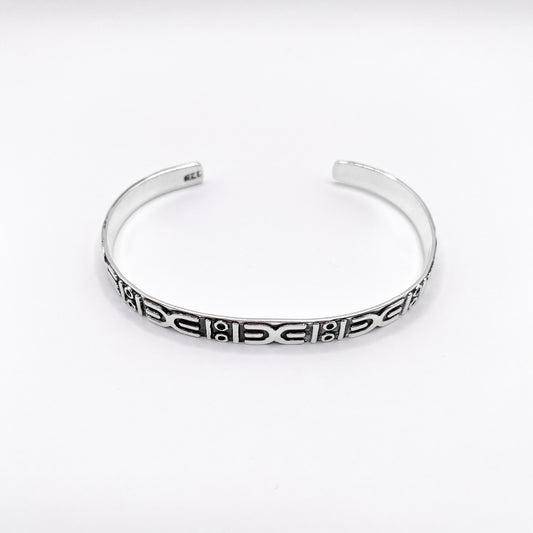 Bracelet ouvert en argent avec motifs ethniques gravés, issu de la boutique en ligne Altiplano. Modèle "APANSAKA" reflétant l’artisanat traditionnel latino-américain.