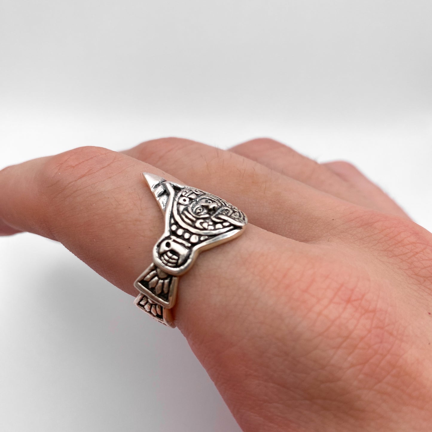 Bague "TONATIUH" en argent finement détaillée, inspirée de motifs traditionnels latino-américains. Disponible chez la boutique Altiplano. Plaquée sur un doigt, elle affiche un design artisanal unique.