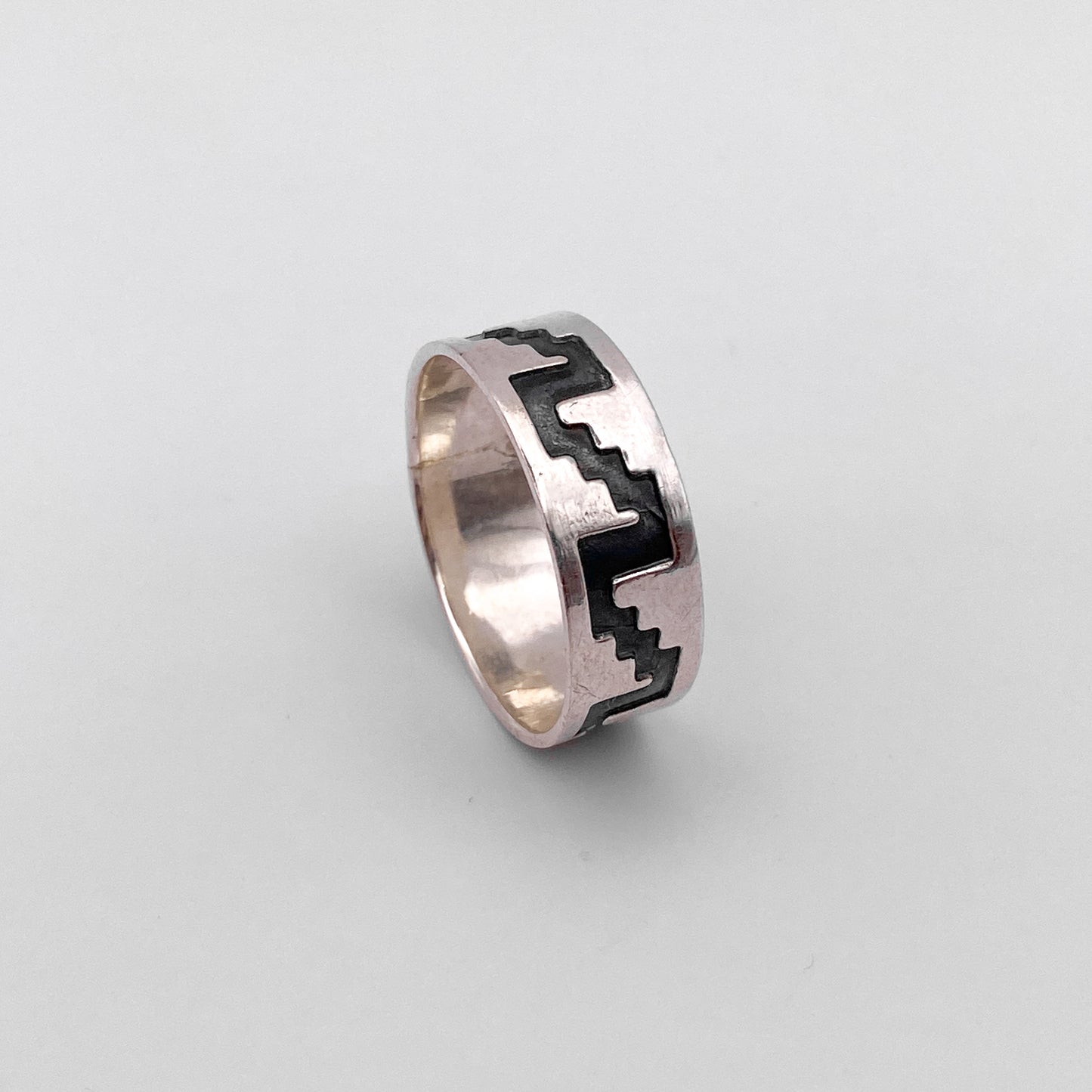 La bague en argent "SAYANI" de la boutique Altiplano présente un motif géométrique noir incrusté, rappelant l'artisanat traditionnel latino-américain. Un bijou élégant et authentique.
