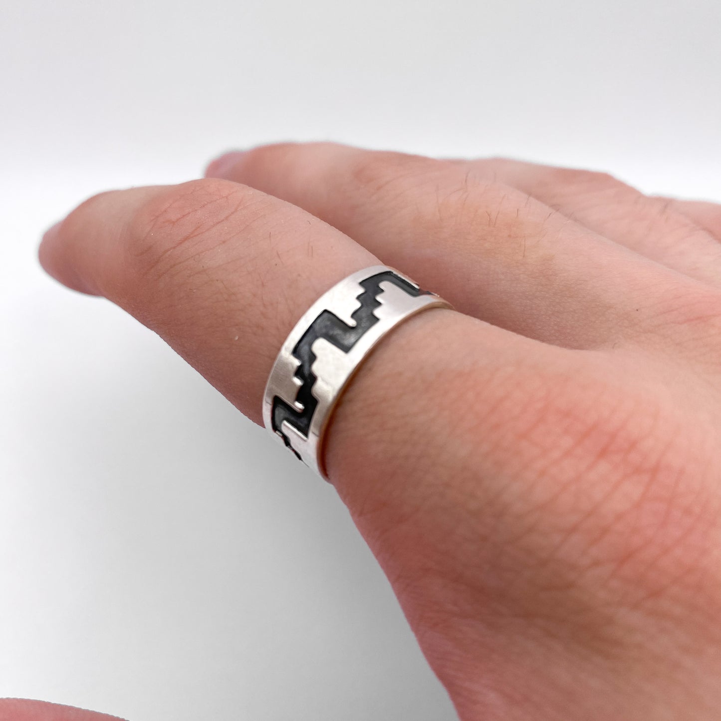 Bague en argent "SAYANI" de la boutique Altiplano, ornée d'un motif géométrique noir distinctif inspiré de l'art latino-américain.