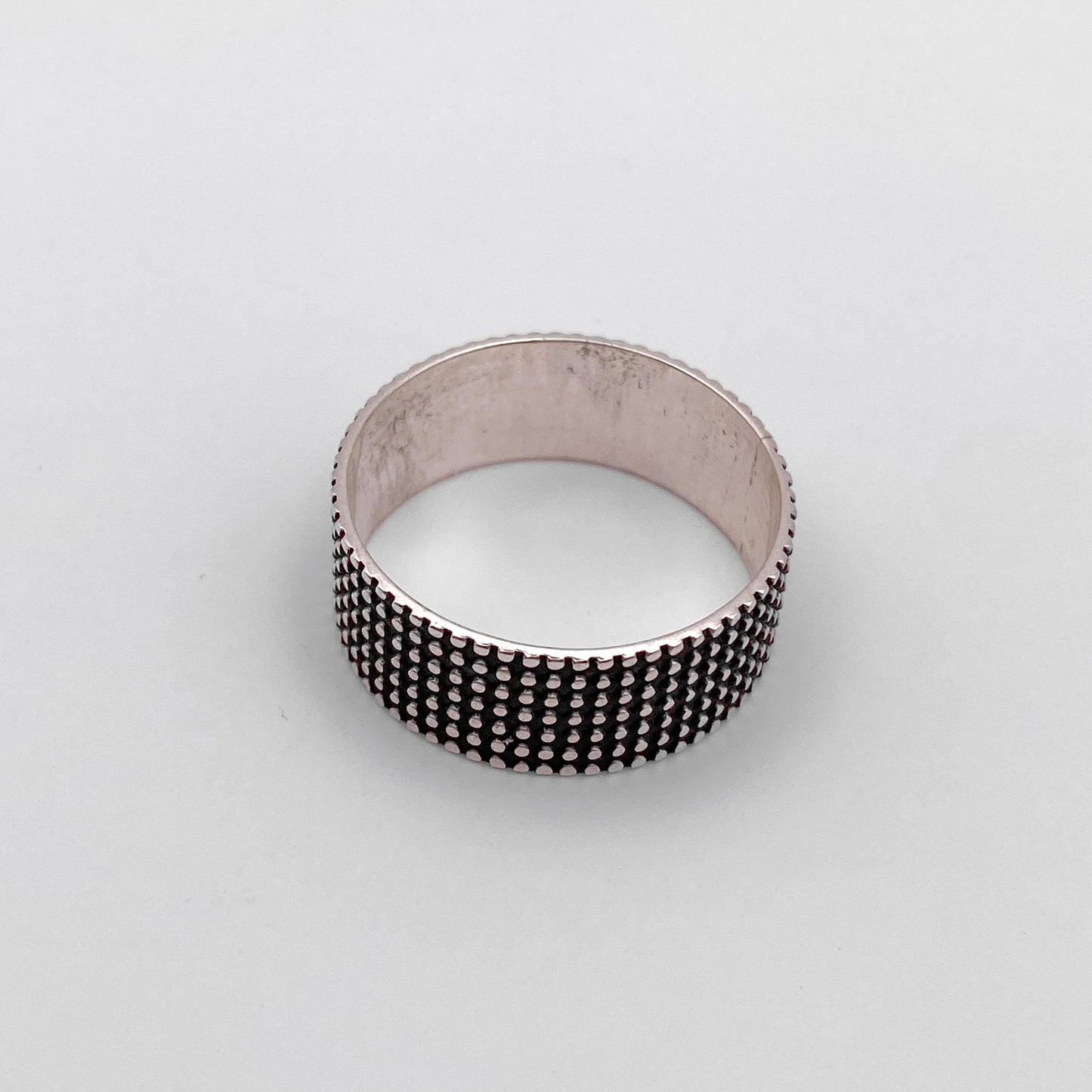 Image d'une bague en argent, intitulée "JAYRI", disponible dans la boutique en ligne Altiplano. La bague présente un motif de petites perles argentées disposées régulièrement sur la surface, offrant une texture unique et raffinée.