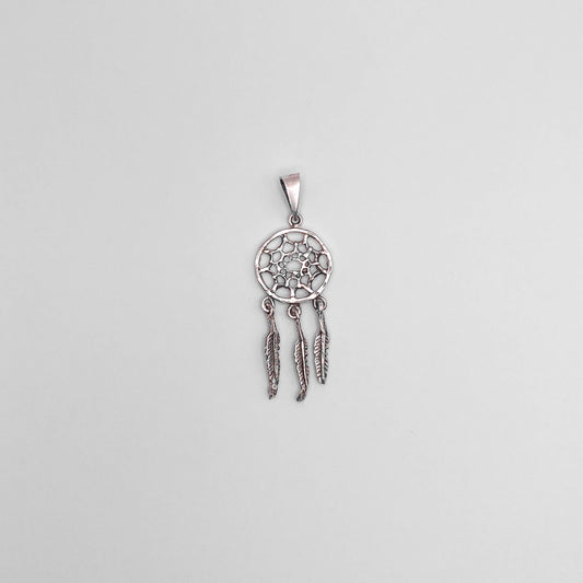 Pendentif en argent finement ciselé représentant un attrape-rêves avec trois plumes pendantes. Parfait pour ajouter une touche bohème à votre look. Disponible dans la boutique en ligne Altiplano, spécialisée dans les bijoux en argent latino-américains.