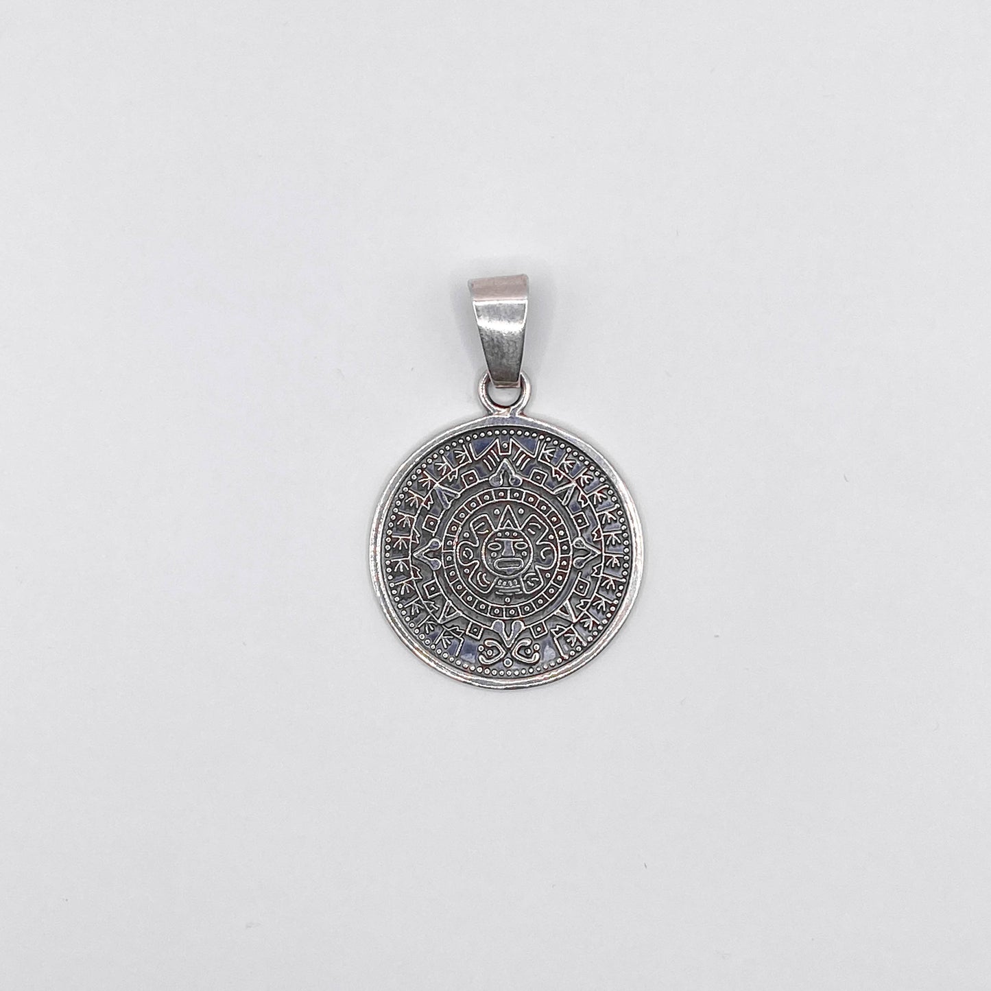 Pendentif en argent représentant un calendrier aztèque détaillé, disponible chez Altiplano, boutique en ligne de bijoux latino-américains en argent.