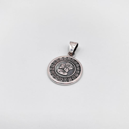 Pendentif en argent de la boutique Altiplano, représentant une figure symbolique latino-américaine entourée de motifs traditionnels.