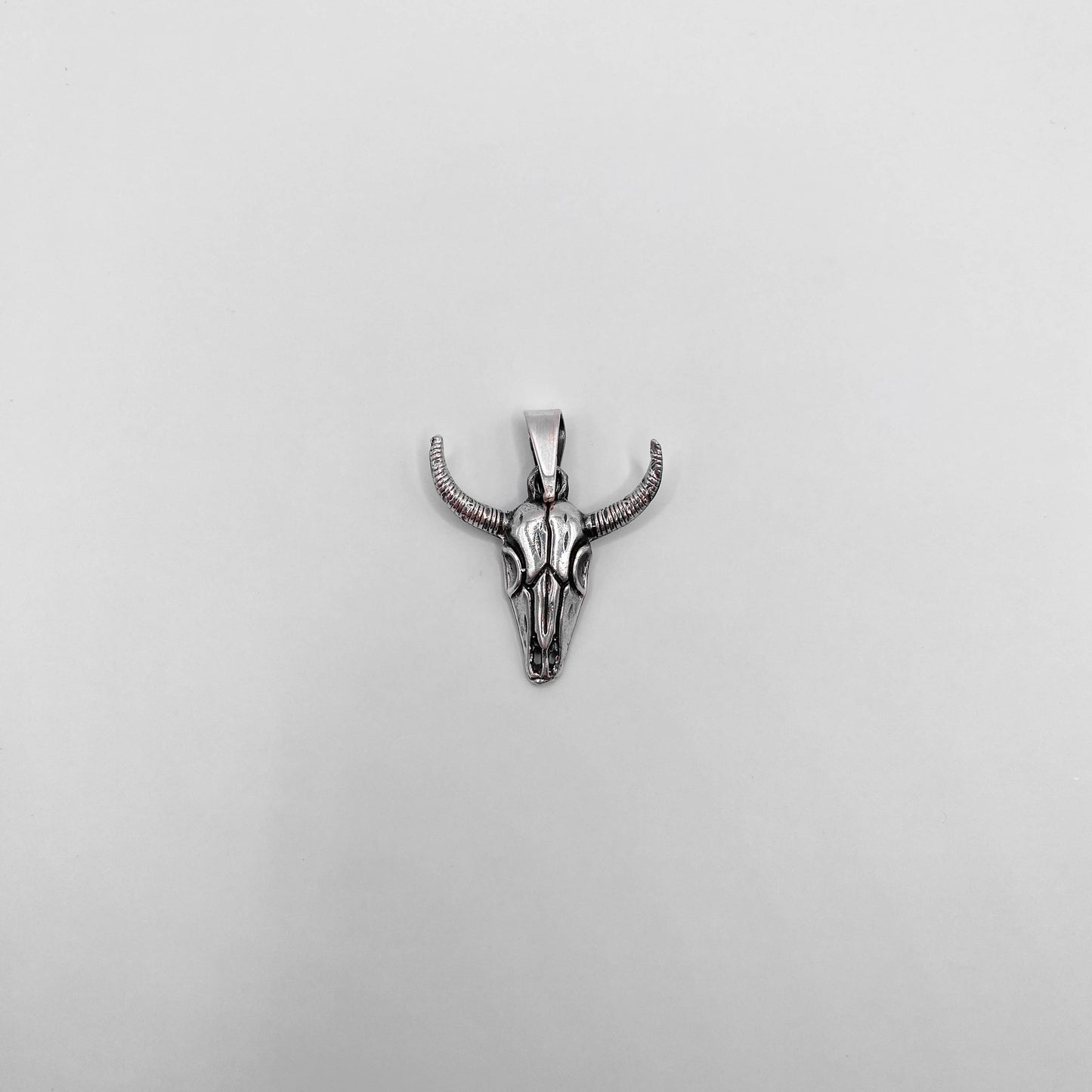 Pendentif en argent "MICTLAN" représentant un crâne de bovin avec des cornes, disponible chez Altiplano, boutique en ligne de bijoux latino-américains.