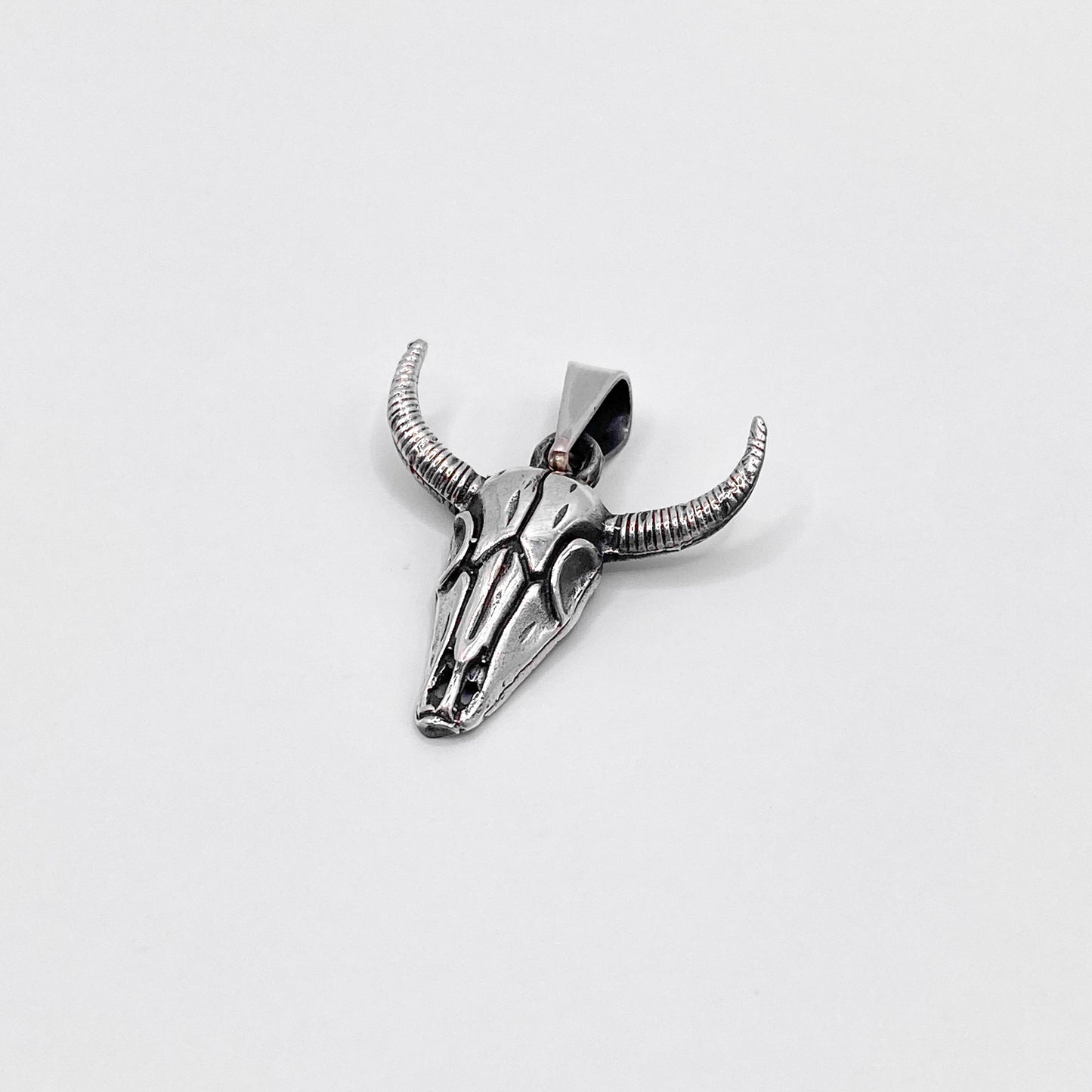 Pendentif en argent représentant un crâne de taureau aux détails finement sculptés. Inspiré par les traditions latino-américaines, ce bijou unique est disponible dans la boutique en ligne Altiplano, spécialisée dans les créations artisanales en argent.