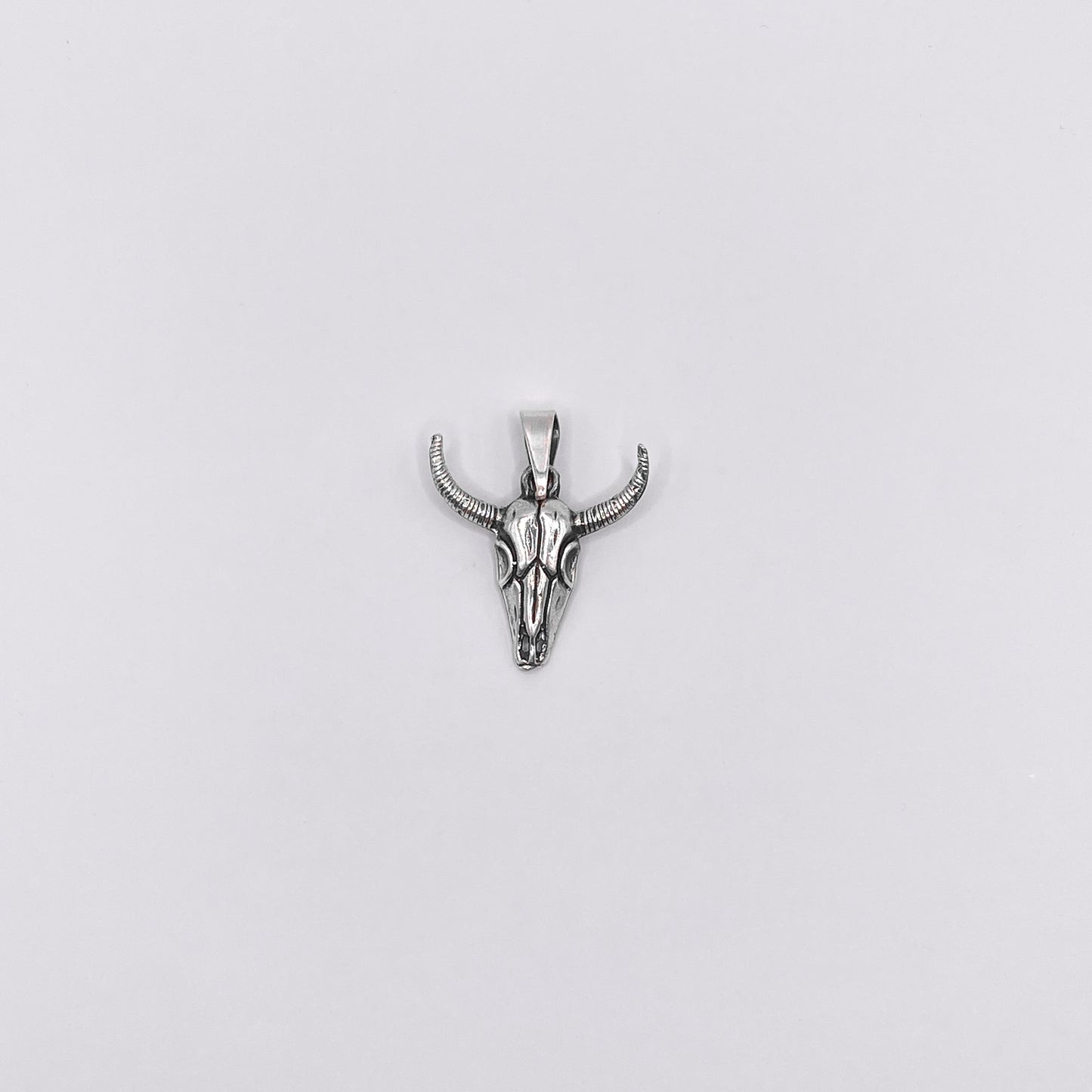 Pendentif en argent fin représentant un crâne de taureau avec des cornes détaillées. Un bijou artisanal au design latin, disponible sur la boutique Altiplano.