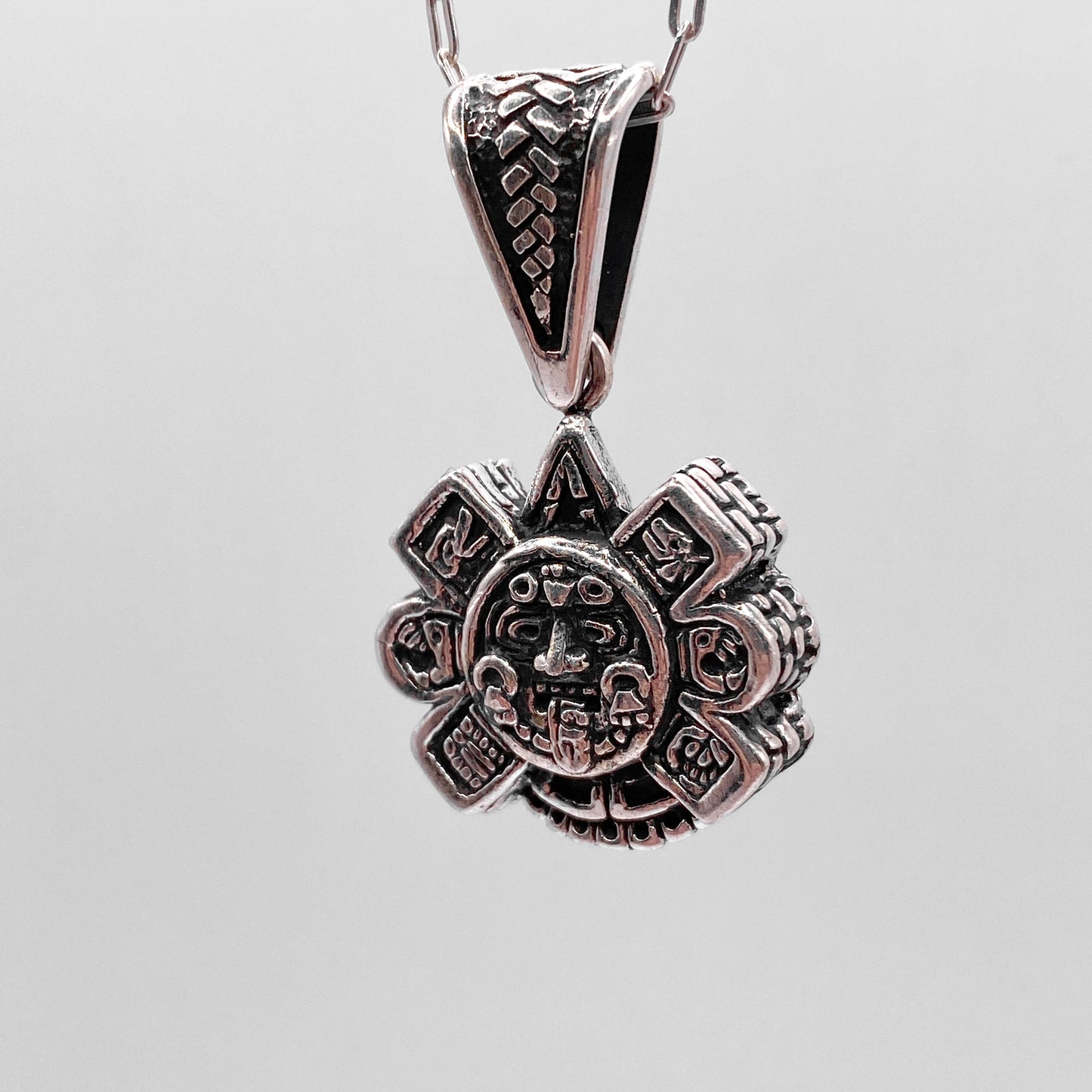 Pendentif en argent finement ouvragé "OLLIN", représentant un motif aztèque, disponible sur la boutique en ligne Altiplano.