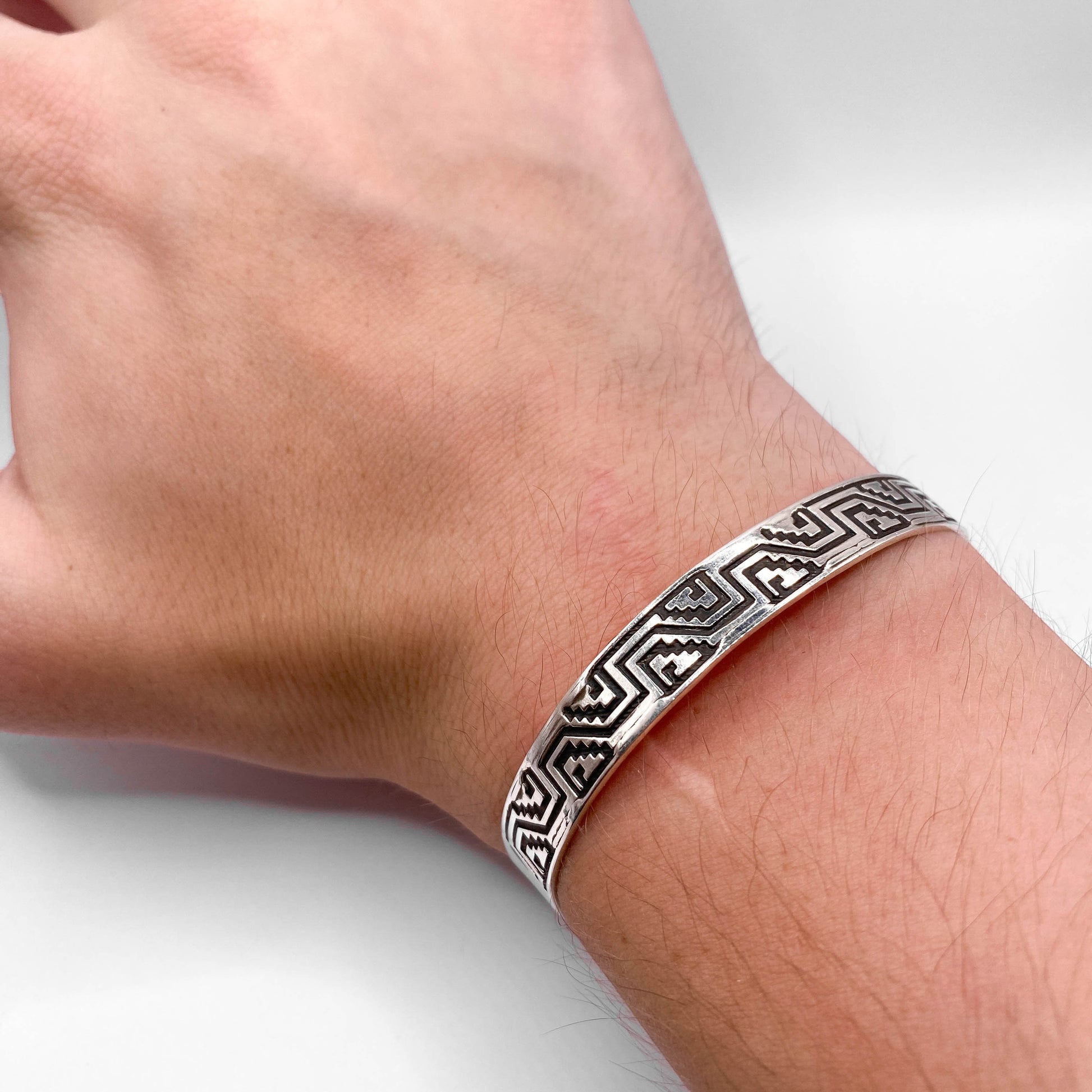 Bracelet en argent "NA'AKAL" de la boutique en ligne Altiplano, présentant des motifs géométriques traditionnels inspirés de l'art latino-américain.