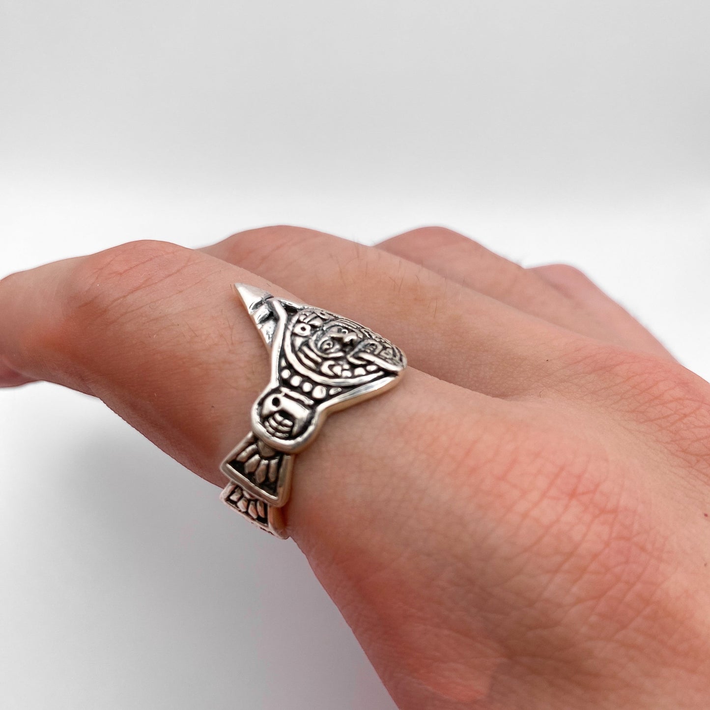 Bague "TONATIUH" en argent finement détaillée, inspirée de motifs traditionnels latino-américains. Disponible chez la boutique Altiplano. Plaquée sur un doigt, elle affiche un design artisanal unique.