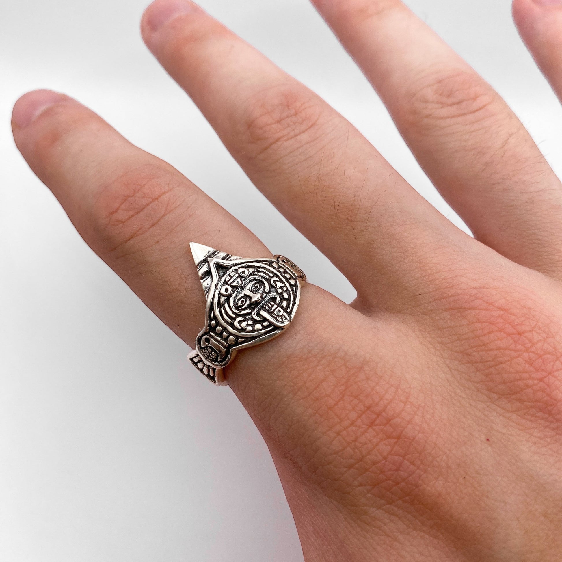 Bague en argent au design détaillé représentant le dieu aztèque Tonatiuh, mettant en avant un motif traditionnel symbolique. Fabriquée par la boutique Altiplano, spécialisée dans les bijoux en argent latino-américains.