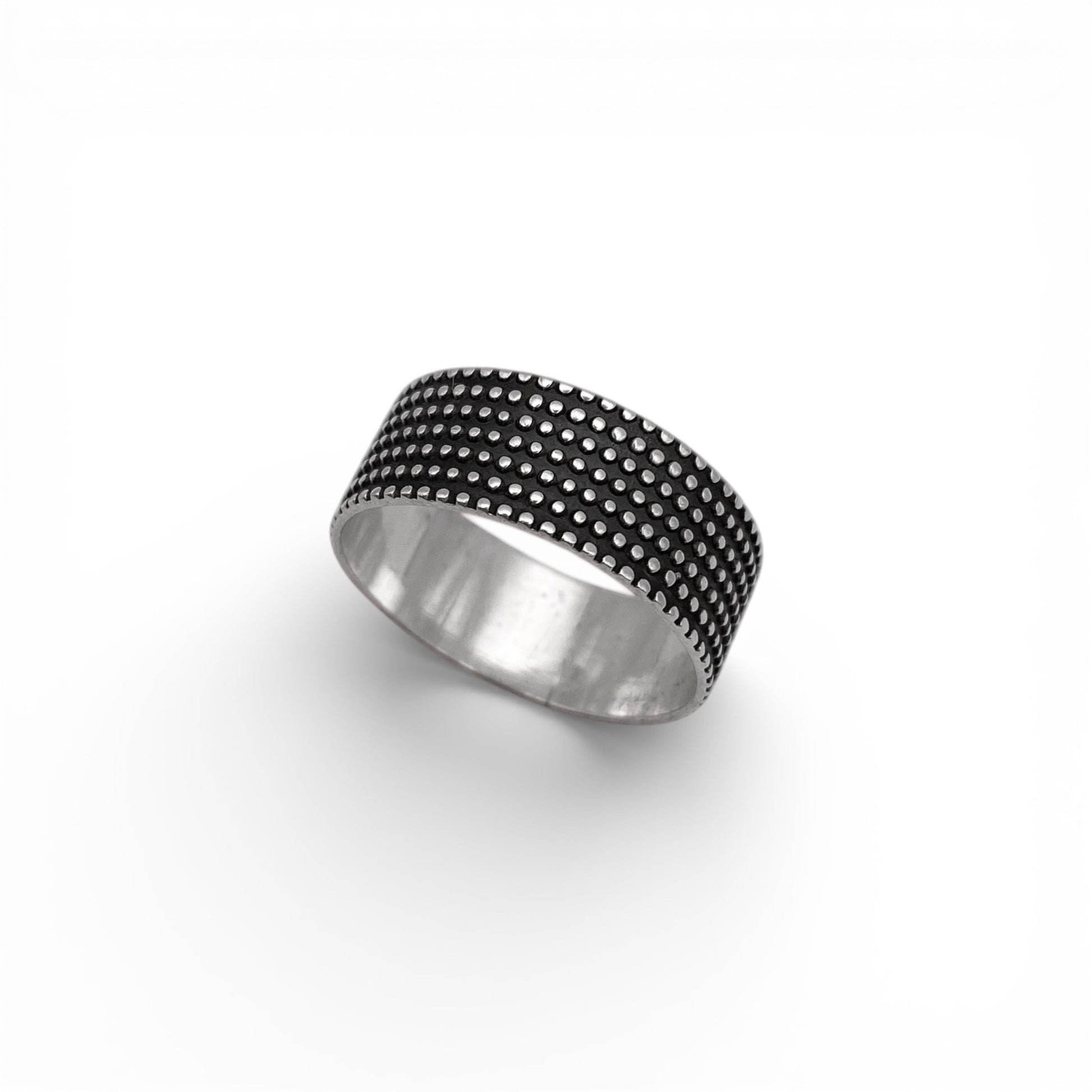 Bague en argent "JAYRI" de la boutique Altiplano, présentant un motif de pois texturés distinctifs sur fond noir. Bijou artisanal latino-américain, élégant et unique.