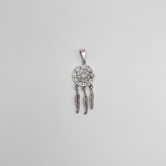 Pendentif en argent de style attrape-rêves avec trois plumes pendantes, proposé par la boutique Altiplano. Réalisé main avec un design délicat et symbolique, ce bijou s'inspire des traditions Ojibwées.