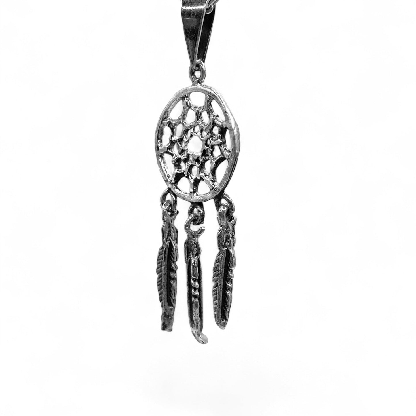 Médaillon en argent représentant un capteur de rêves avec trois plumes suspendues. Le design est finement ciselé, combinant inspiration traditionnelle et artisanat latino-américain. Disponible dans la boutique en ligne Altiplano.