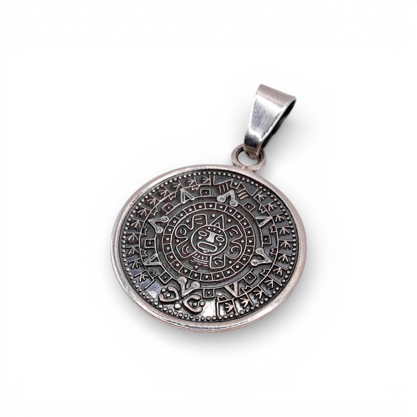Pendentif rond en argent "AZTECA" de la boutique Altiplano, orné de motifs aztèques détaillés, évoquant l'artisanat latin américain traditionnel.
