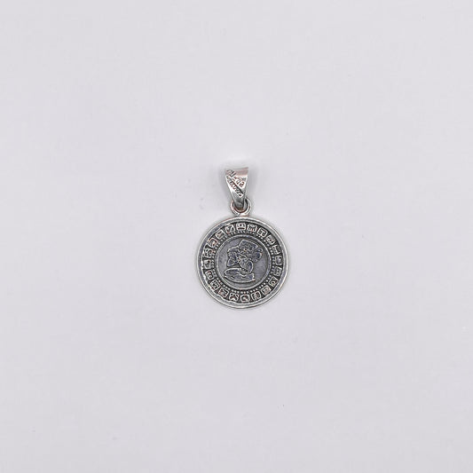 Pendentif en argent représentant un motif circulaire avec des symboles gravés et un dessin central, disponible à la boutique Altiplano.