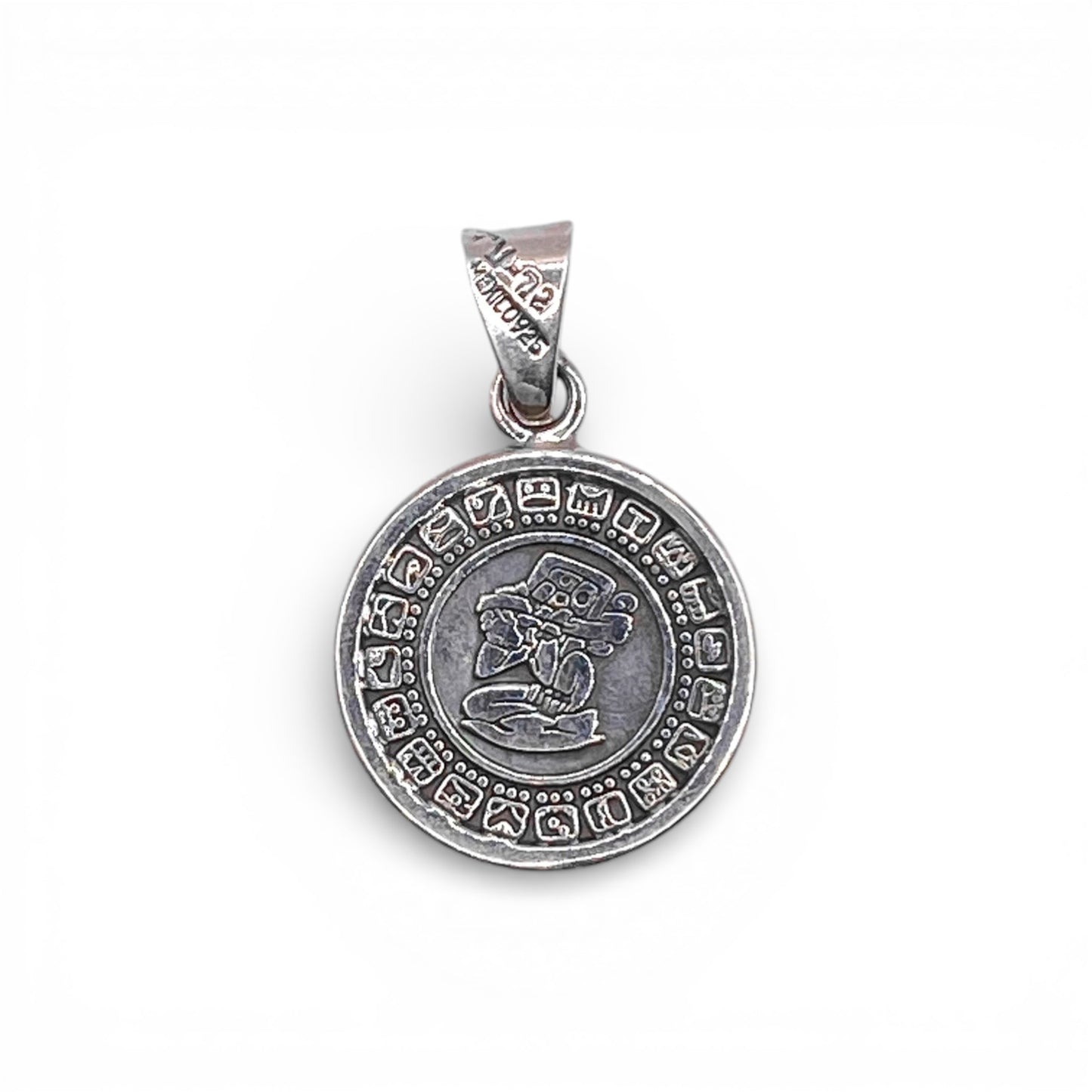 Pendentif en argent représentant un motif circulaire avec des symboles gravés et un dessin central, disponible à la boutique Altiplano.