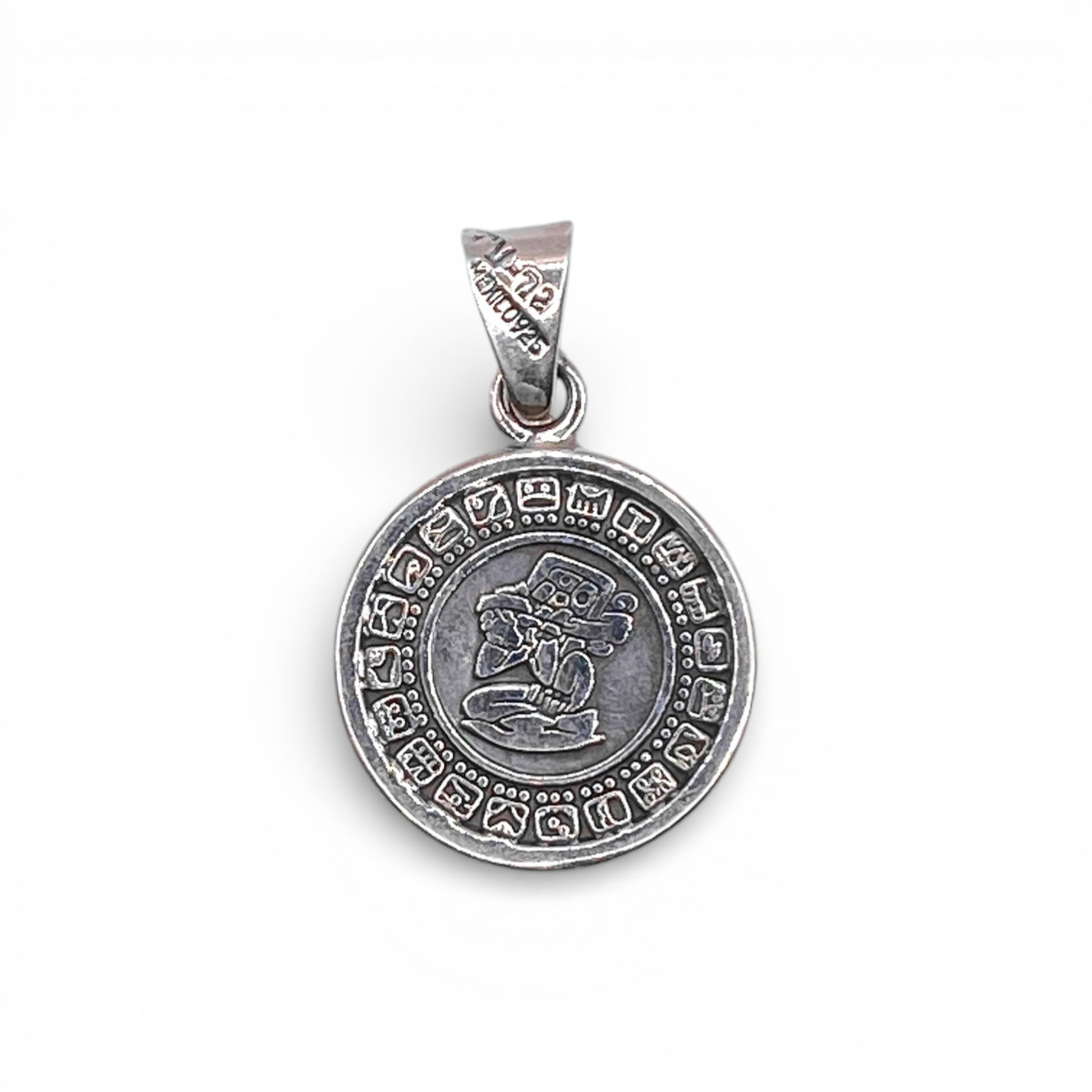 Pendentif en argent représentant un motif circulaire avec des symboles gravés et un dessin central, disponible à la boutique Altiplano.