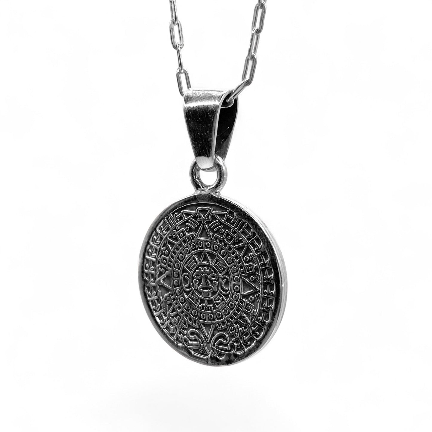 Colier en argent de la boutique Altiplano, intitulé "OMEKA'", présentant un pendentif rond finement gravé d'un motif inspiré de l'art latino-américain.