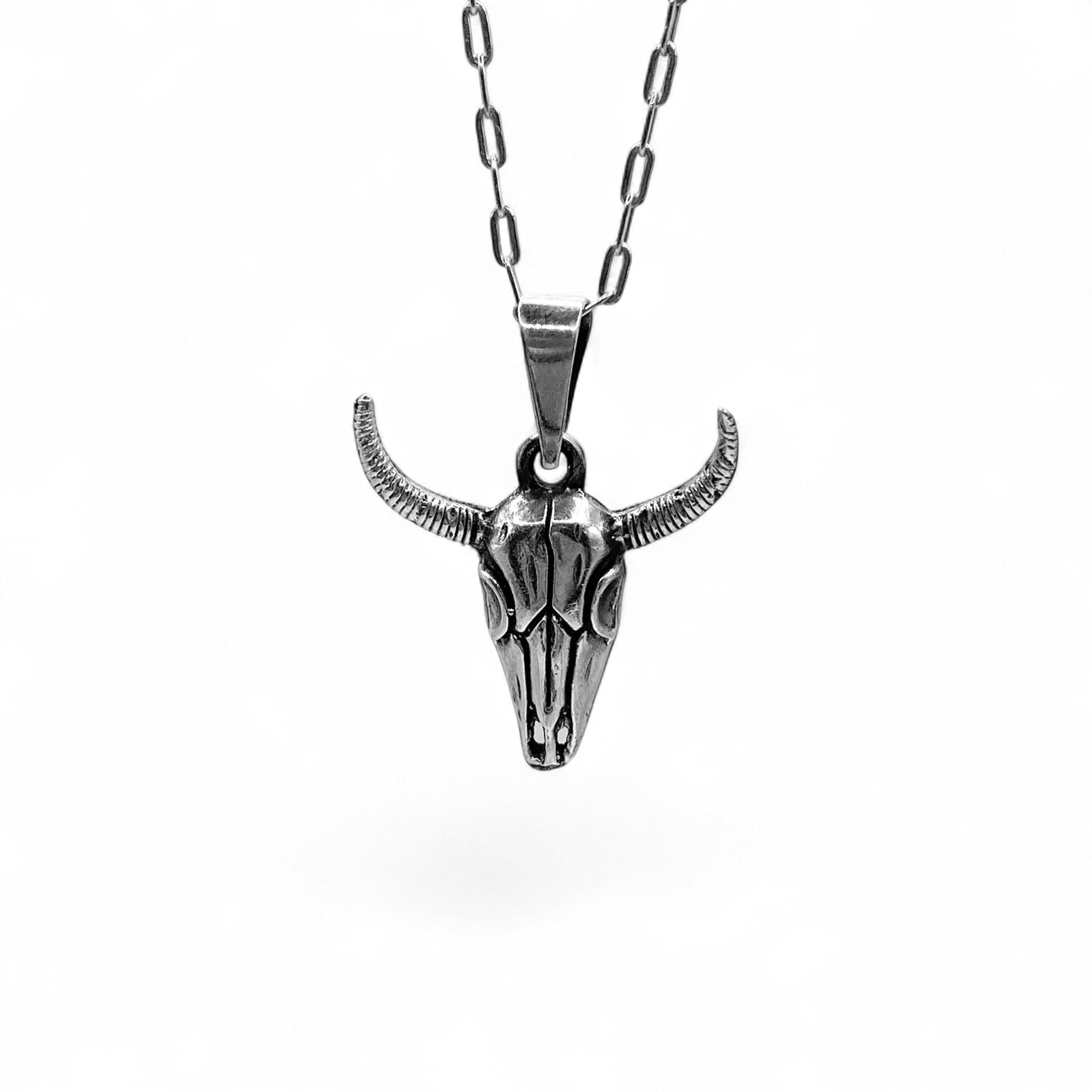 Collier en argent de la boutique Altiplano intitulé "MICTLAN", représentant un pendentif en forme de crâne de taureau avec des détails fins et des cornes incurvées.